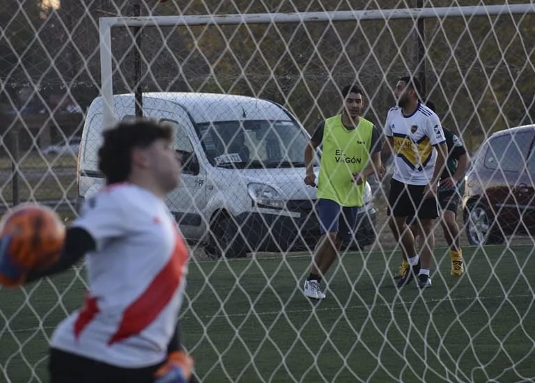 Jugador junto a un arco de fútbol con red de cerramiento