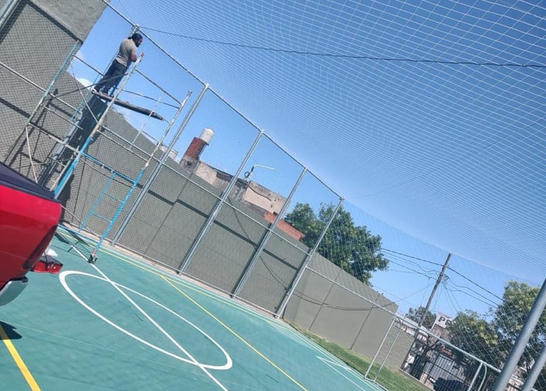Cancha polideportiva con red de cerramiento contra el cielo despejado